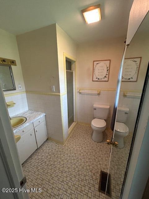 2030 US Highway 17, Merry Hill, NC 27957 - bathroom with tile walls, toilet, vanity, a shower stall, and a wainscoted wall