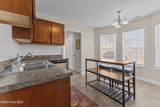 kitchen with an inviting chandelier, a sink, tasteful backsplash, visible vents, and dark countertops