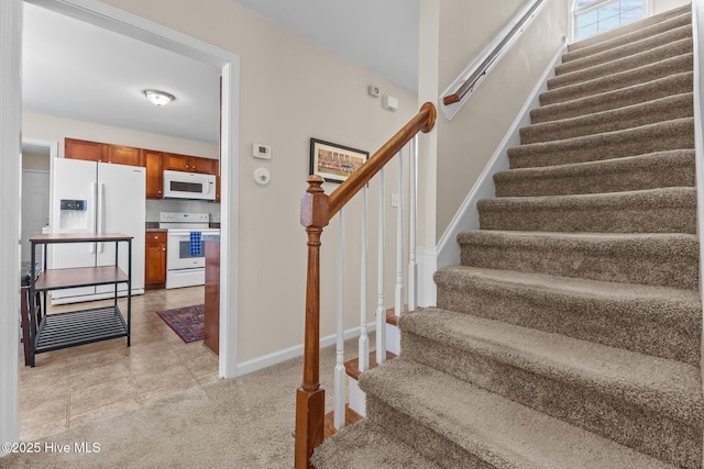 stairs featuring baseboards and tile patterned flooring