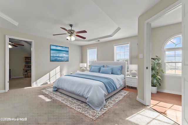 carpeted bedroom with baseboards, visible vents, ceiling fan, and a walk in closet