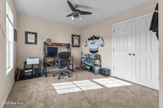 carpeted home office with a ceiling fan and baseboards