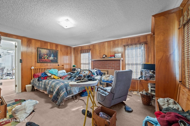 bedroom with wooden walls, light carpet, and a textured ceiling