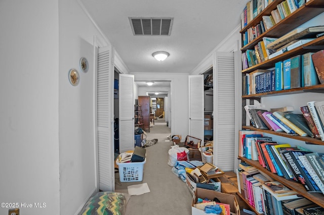 corridor with crown molding, concrete floors, and a textured ceiling