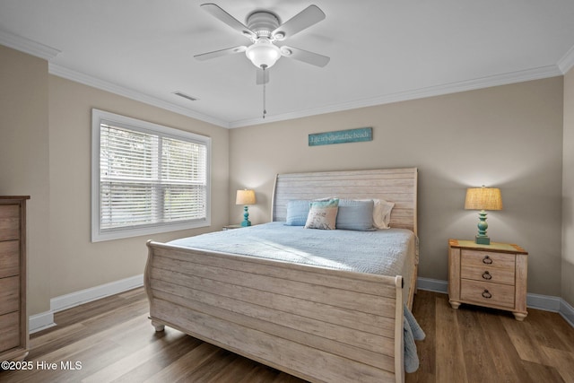 bedroom with hardwood / wood-style flooring, ornamental molding, and ceiling fan