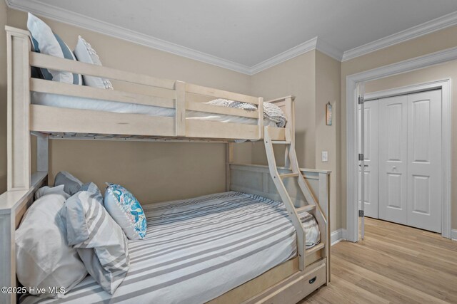 bedroom featuring crown molding and light hardwood / wood-style flooring