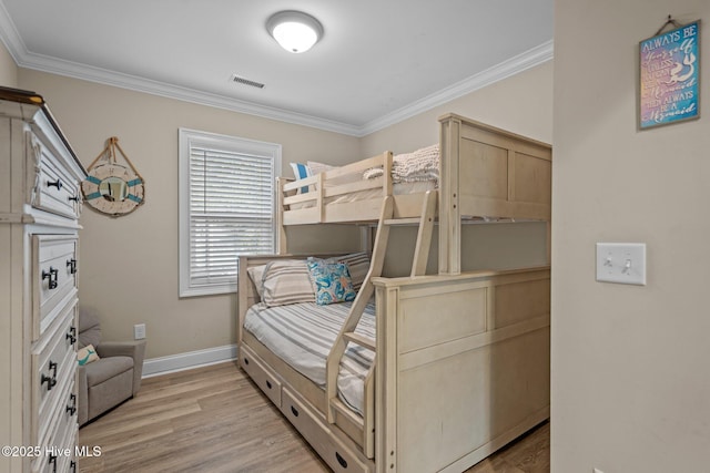 bedroom featuring ornamental molding and light hardwood / wood-style flooring