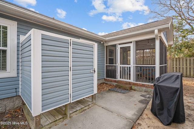 view of patio featuring a grill and a sunroom