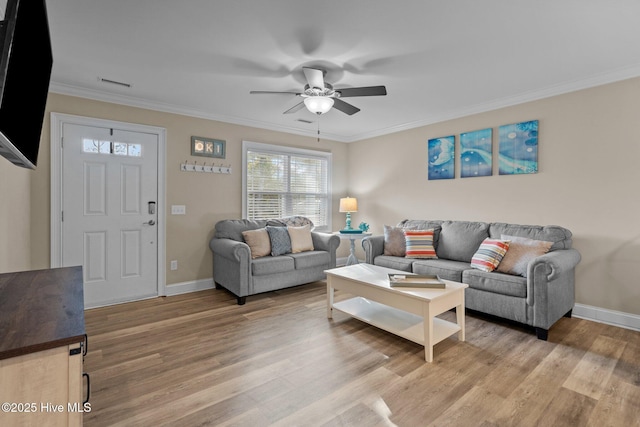 living room with hardwood / wood-style flooring, ceiling fan, and ornamental molding