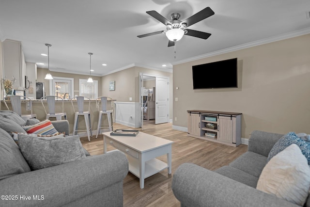 living room with ornamental molding, ceiling fan, and light hardwood / wood-style floors