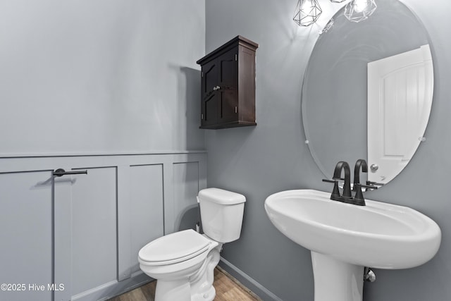 bathroom with hardwood / wood-style floors, sink, and toilet