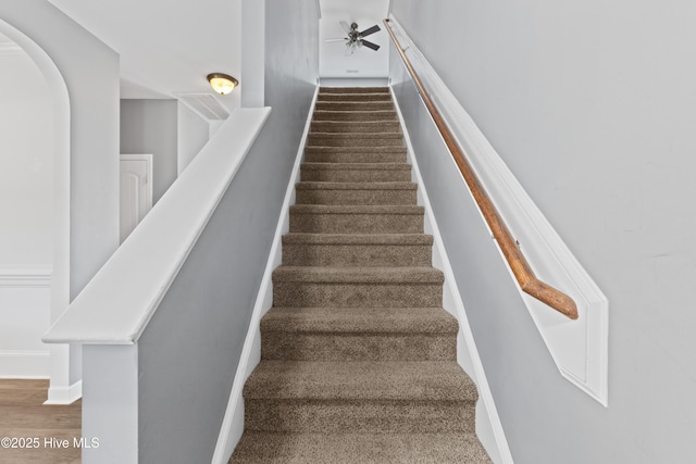 staircase featuring ceiling fan