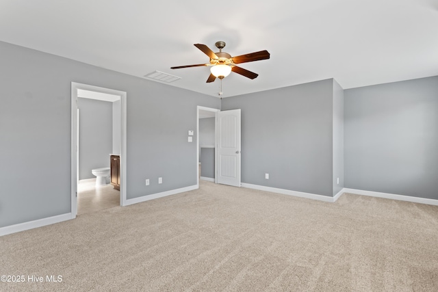 unfurnished bedroom featuring light carpet, connected bathroom, and ceiling fan