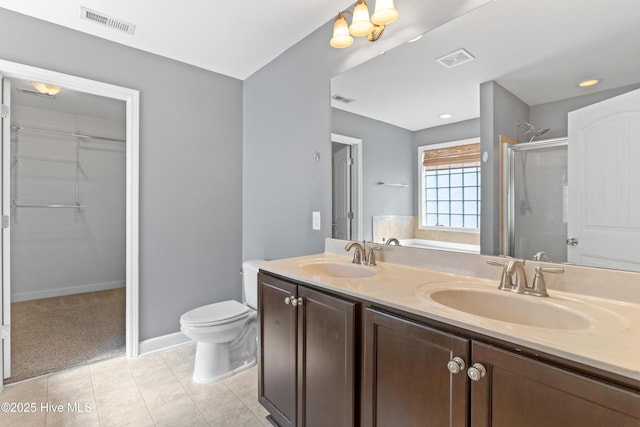 bathroom featuring walk in shower, vanity, toilet, and tile patterned flooring