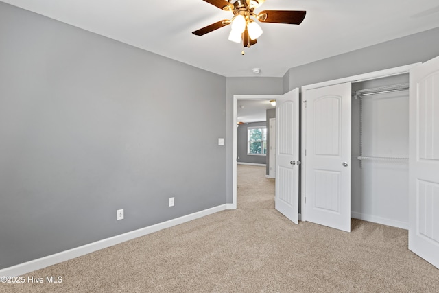 unfurnished bedroom with ceiling fan, light colored carpet, and a closet