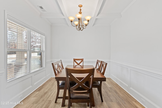 dining space with coffered ceiling, a notable chandelier, beam ceiling, and light hardwood / wood-style flooring