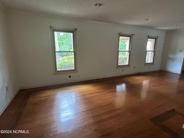 spare room with hardwood / wood-style floors and ornamental molding