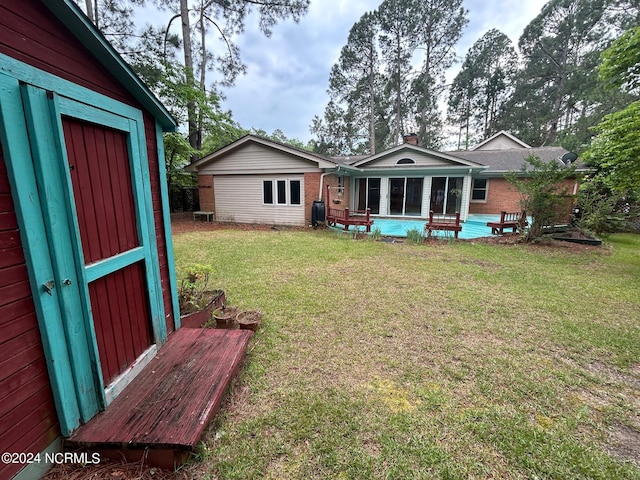 view of yard with a storage unit and a sunroom