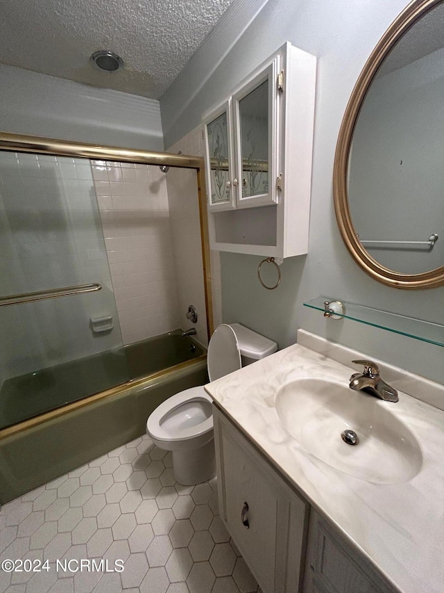 full bathroom featuring vanity, a textured ceiling, toilet, and tiled shower / bath