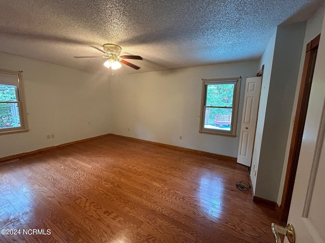 empty room with hardwood / wood-style flooring, ceiling fan, and a textured ceiling