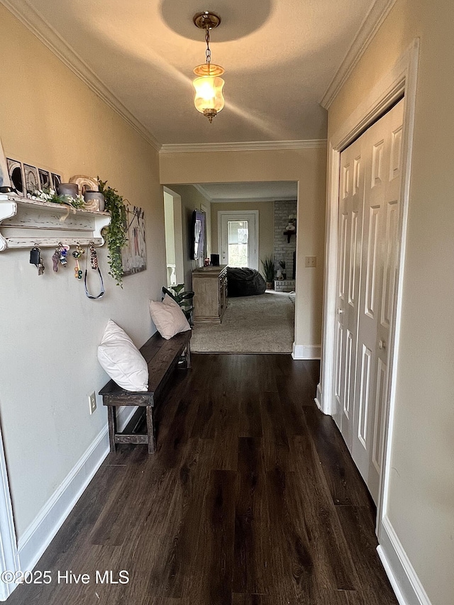 hall featuring crown molding, dark wood finished floors, and baseboards