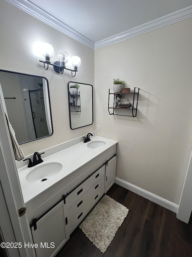 bathroom with double vanity, wood finished floors, a sink, and crown molding