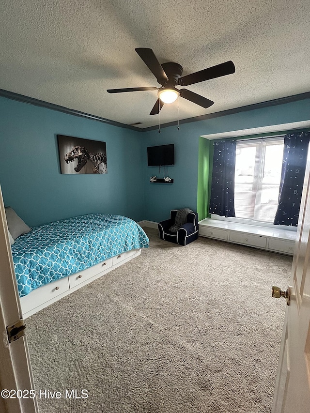 carpeted bedroom featuring a ceiling fan, crown molding, and a textured ceiling