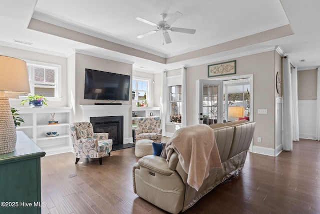 living room featuring a raised ceiling and dark wood-style flooring