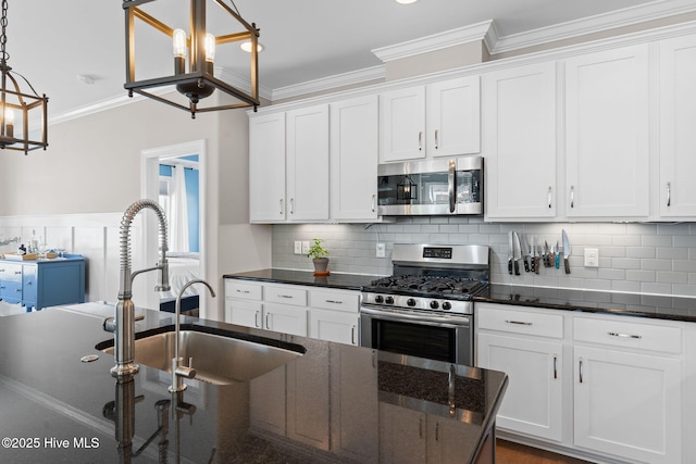 kitchen with stainless steel appliances, hanging light fixtures, backsplash, ornamental molding, and white cabinets