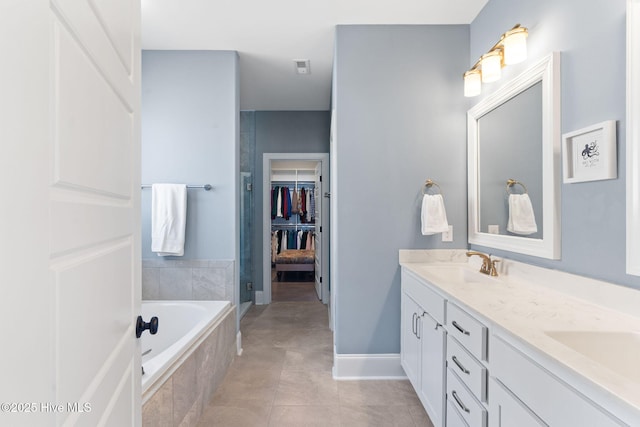 full bathroom featuring double vanity, a sink, a shower stall, tile patterned flooring, and a bath