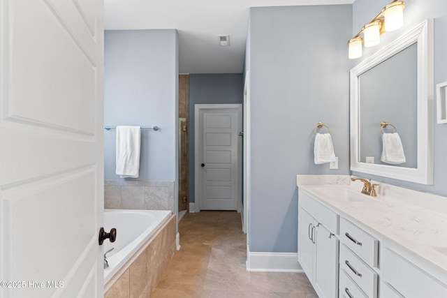 bathroom with vanity, a shower stall, tile patterned flooring, baseboards, and a bath