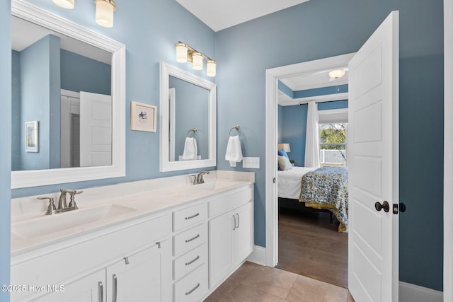 bathroom with double vanity, tile patterned flooring, a sink, and ensuite bathroom