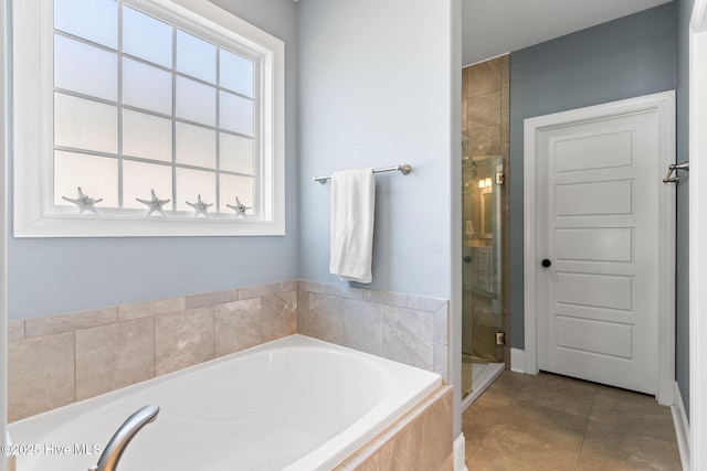 full bathroom with a garden tub, a shower stall, and tile patterned floors