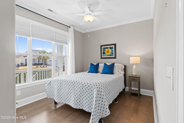 bedroom with baseboards, visible vents, a ceiling fan, dark wood-style floors, and crown molding