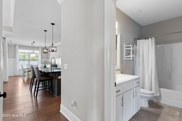 full bathroom featuring toilet, shower / bath combo, wood finished floors, and vanity