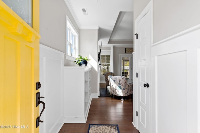 foyer featuring baseboards, dark wood finished floors, visible vents, and crown molding