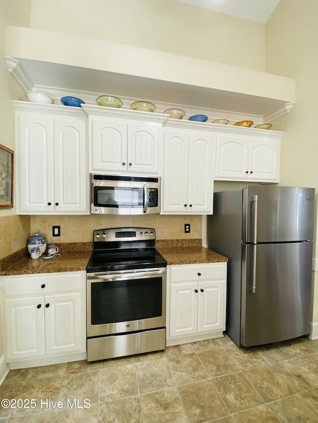 kitchen featuring stainless steel appliances, ornamental molding, white cabinets, and decorative backsplash