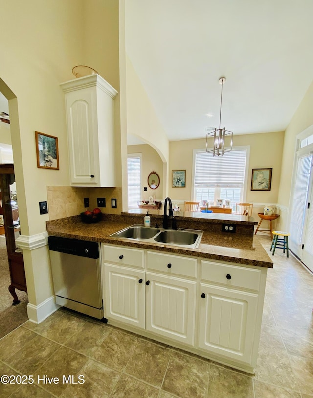 kitchen with decorative light fixtures, white cabinetry, sink, stainless steel dishwasher, and kitchen peninsula