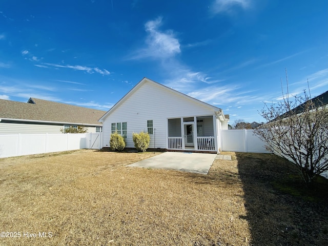 back of property featuring a lawn and a patio area