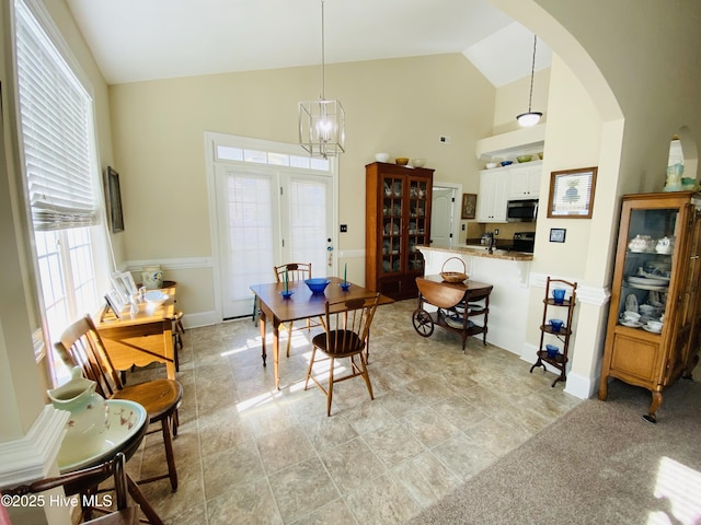 dining area with high vaulted ceiling