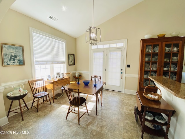 dining area featuring lofted ceiling and an inviting chandelier