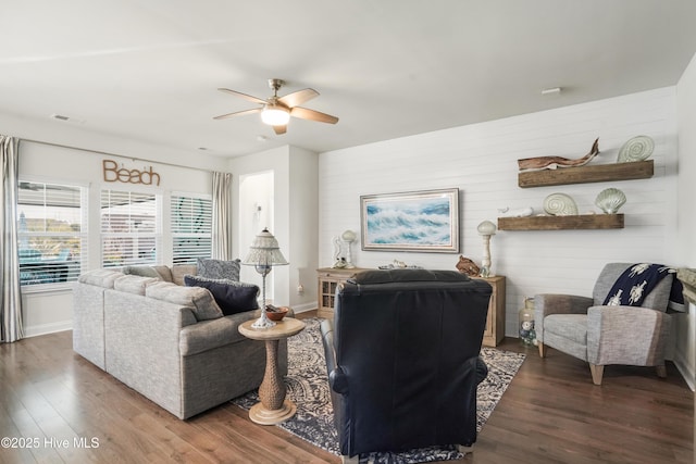 living room featuring ceiling fan and dark hardwood / wood-style floors