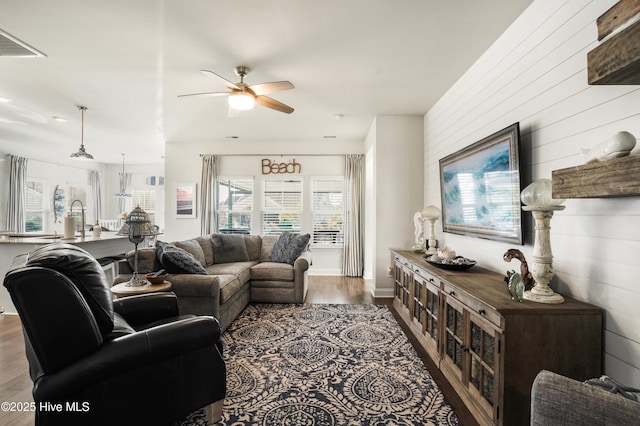 living room with ceiling fan and dark hardwood / wood-style floors