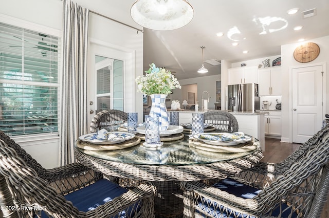 dining area featuring sink and dark wood-type flooring