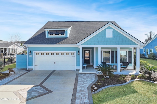 view of front of home with a porch, a garage, and a front lawn