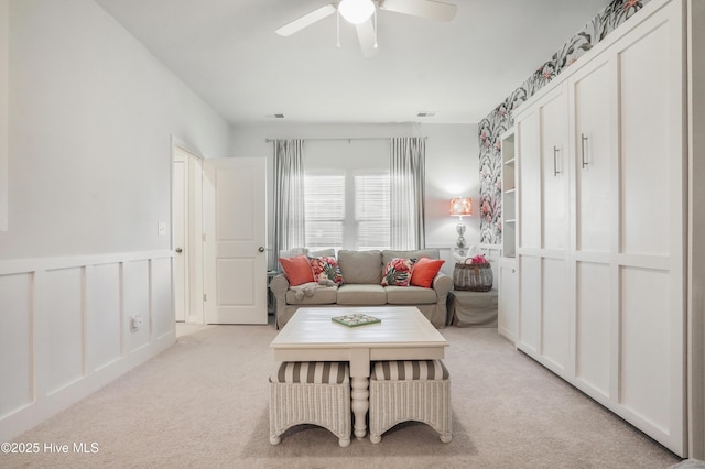 carpeted living room with ceiling fan