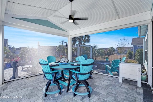 sunroom / solarium with a wealth of natural light, vaulted ceiling, and ceiling fan