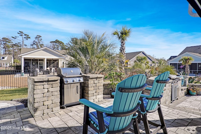 view of patio featuring an outdoor kitchen, a grill, and a sunroom