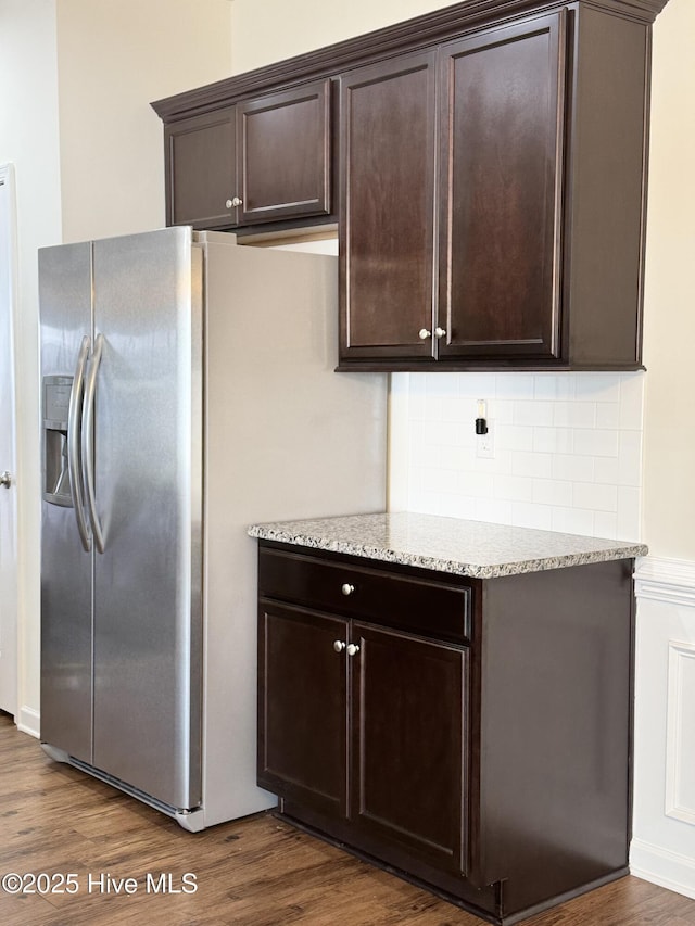 kitchen featuring dark wood-type flooring, tasteful backsplash, light stone countertops, and dark brown cabinets