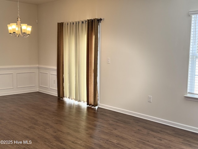 unfurnished room featuring dark hardwood / wood-style flooring and a chandelier