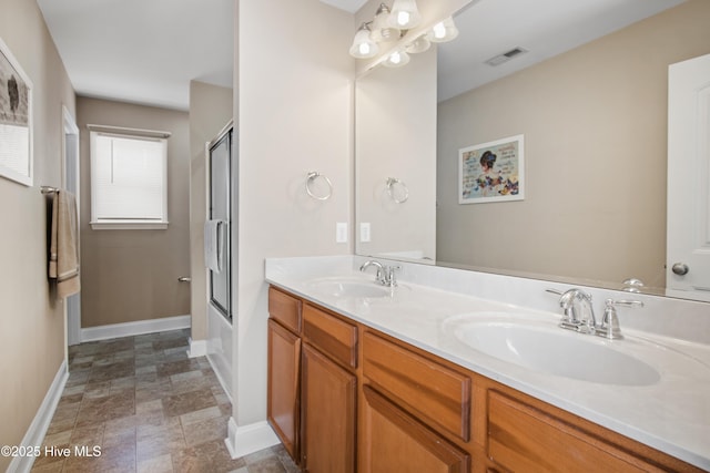 bathroom with vanity and combined bath / shower with glass door